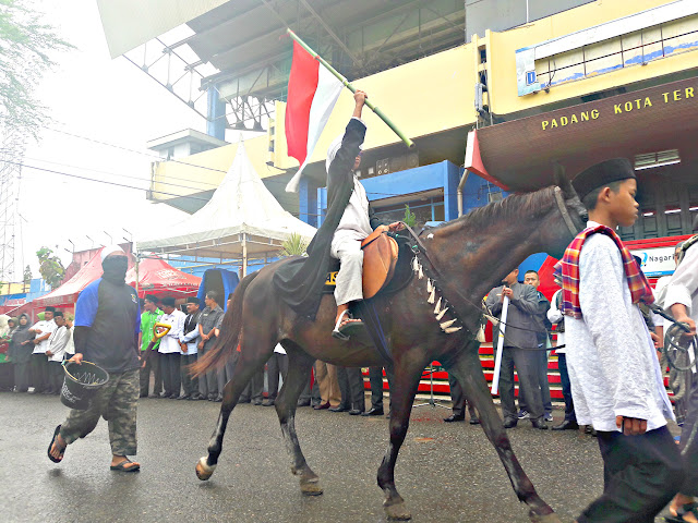 Santri menunjukkan kebolehan menunggangi kuda sembari membawa Bendera Merah Putih pada pawai ta’aruf peringatan Hari Santri Nasional ke-V tahun 2019 di Gor H. Agus Salim, Padang, Selasa (22/10/2019). Santri menunjukkan kebolehan menunggangi kuda sembari membawa Bendera Merah Putih pada pawai ta’aruf peringatan Hari Santri Nasional ke-V tahun 2019 di Gor H. Agus Salim, Padang, Selasa (22/10/2019).